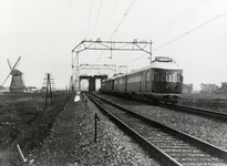 807063 Afbeelding van twee gekoppelde treinstellen mat. 1935 ( Hoek van Hollanders ) van de N.S. ter hoogte van de brug ...